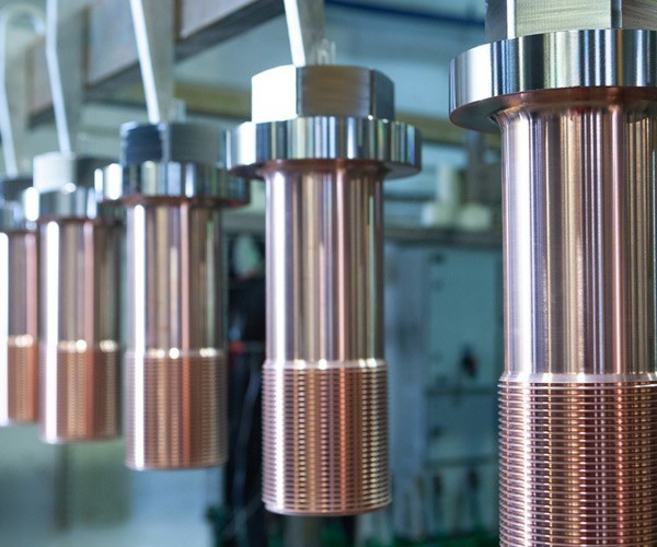 Machine parts being treated with copper plating